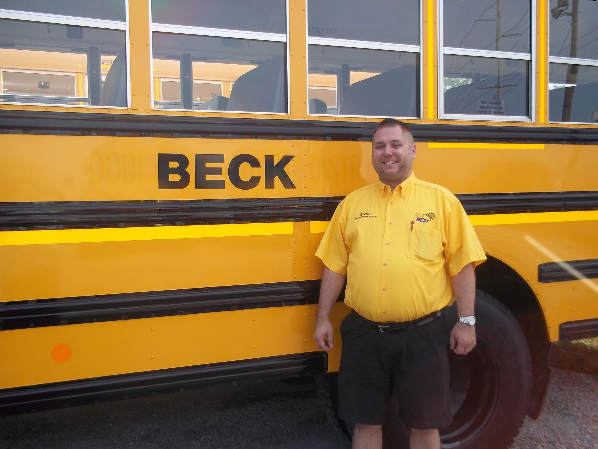 Steve standing beside a school bus marked Beck